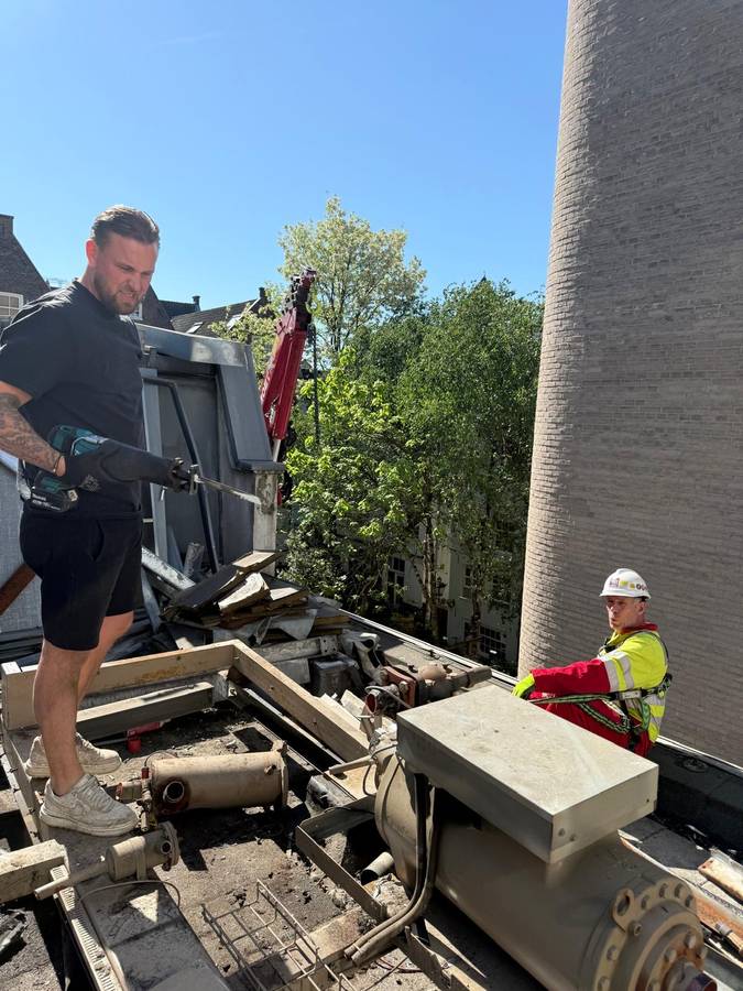 Sloopwerk op dak met kraan en werklieden