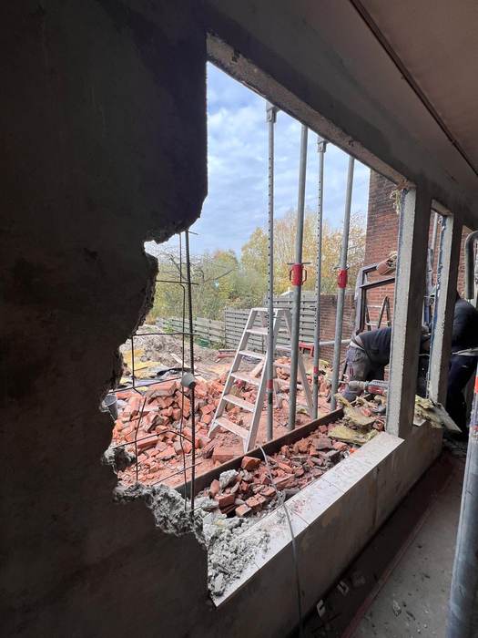Doorbraak in muur, zicht op tuin